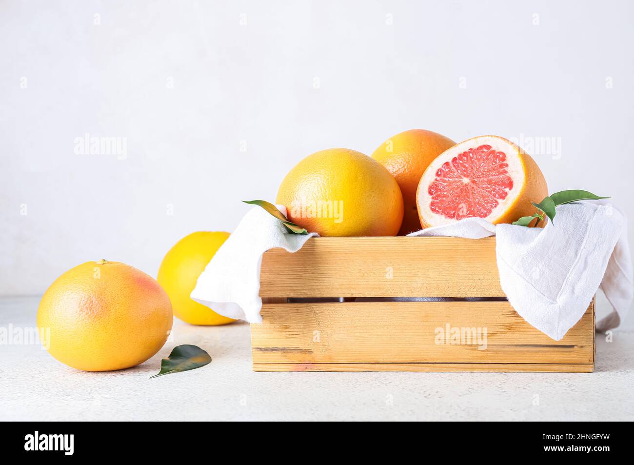 Box with delicious grapefruits on light background Stock Photo