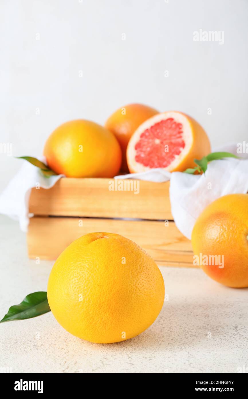 Box with delicious grapefruits on light background Stock Photo