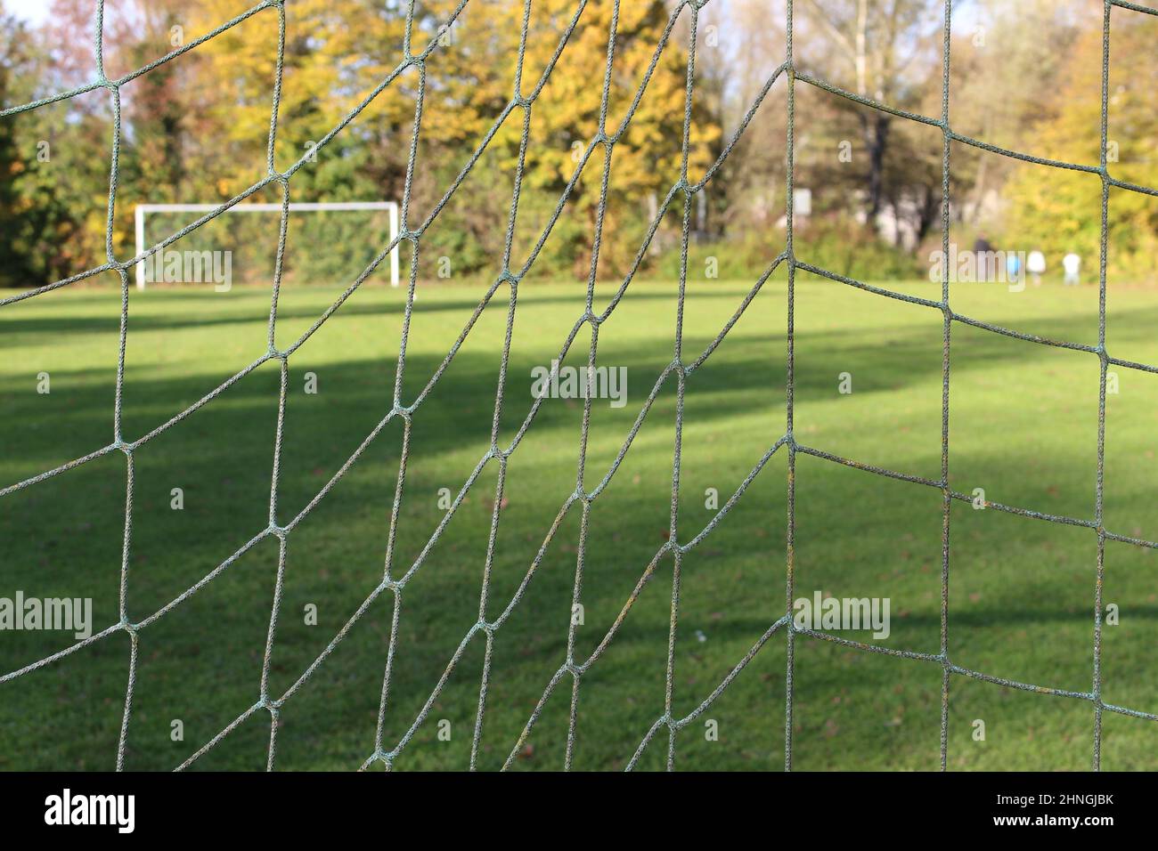 Football net, with blurred football or soccer field in the background