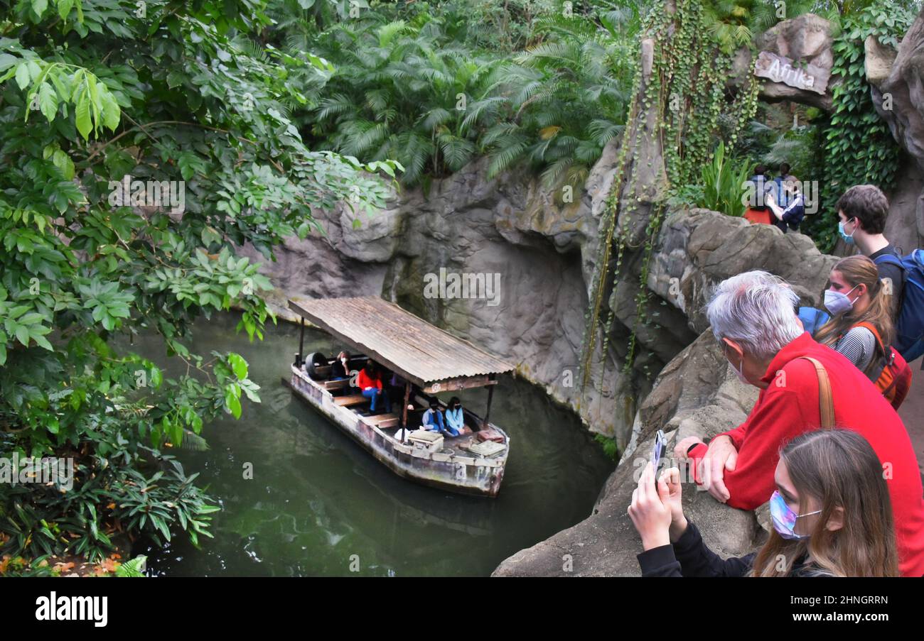 Leipzig, Germany. 16th Feb, 2022. Visitors watch a boat on the Gamanil at the zoo's Gondwanaland at a summery 25 degrees. The facility with tropical rainforest of Africa, Asia and South America, which was opened 10 years ago, features about 500 different plant species and about 170 exotic animals. The zoological garden, which is park-like on 26 hectares, is one of the most species-rich zoos in Europe and recently came in second in a zoo ranking in Europe, making it first in Germany. Credit: Waltraud Grubitzsch/dpa-Zentralbild/ZB/dpa/Alamy Live News Stock Photo