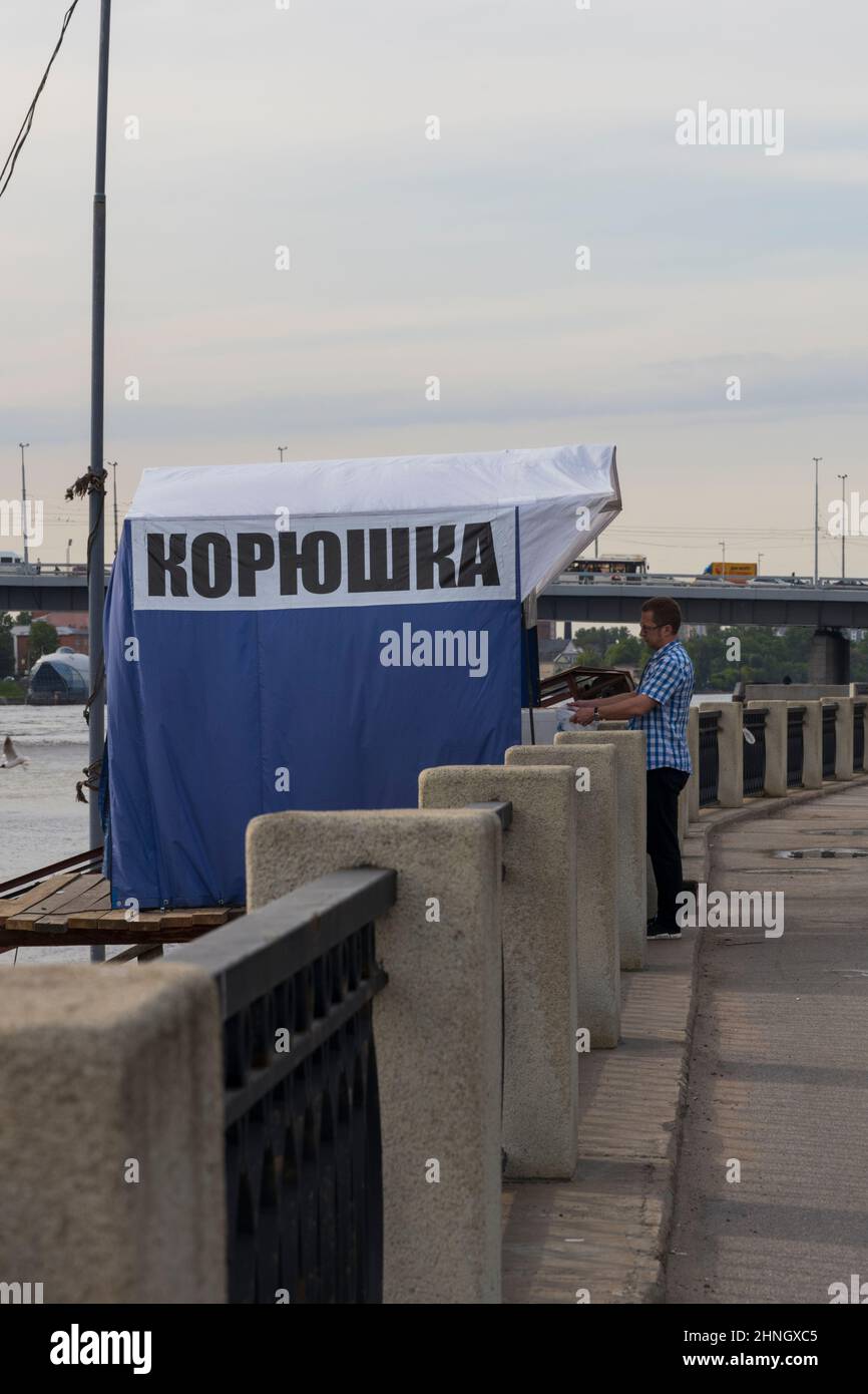 Saint-Petersburg, Russia - May 25, 2021: Customer near a fishing tent with the inscription in Russian 'Smelt' in the smelt fishing season Stock Photo