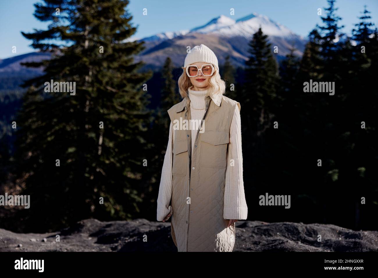 woman in autumn clothes stands on a rock blue sky landscape Stock Photo