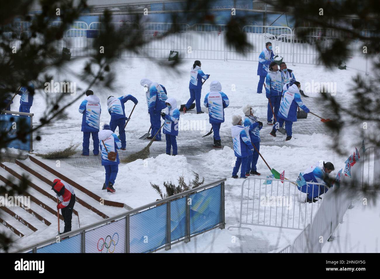 2022 Beijing Olympics - Bobsleigh - 2-woman Official Training - National Sliding Centre, Beijing, China - February 17, 2022. Volunteers clear the snow at the venue. REUTERS/Edgar Su Stock Photo