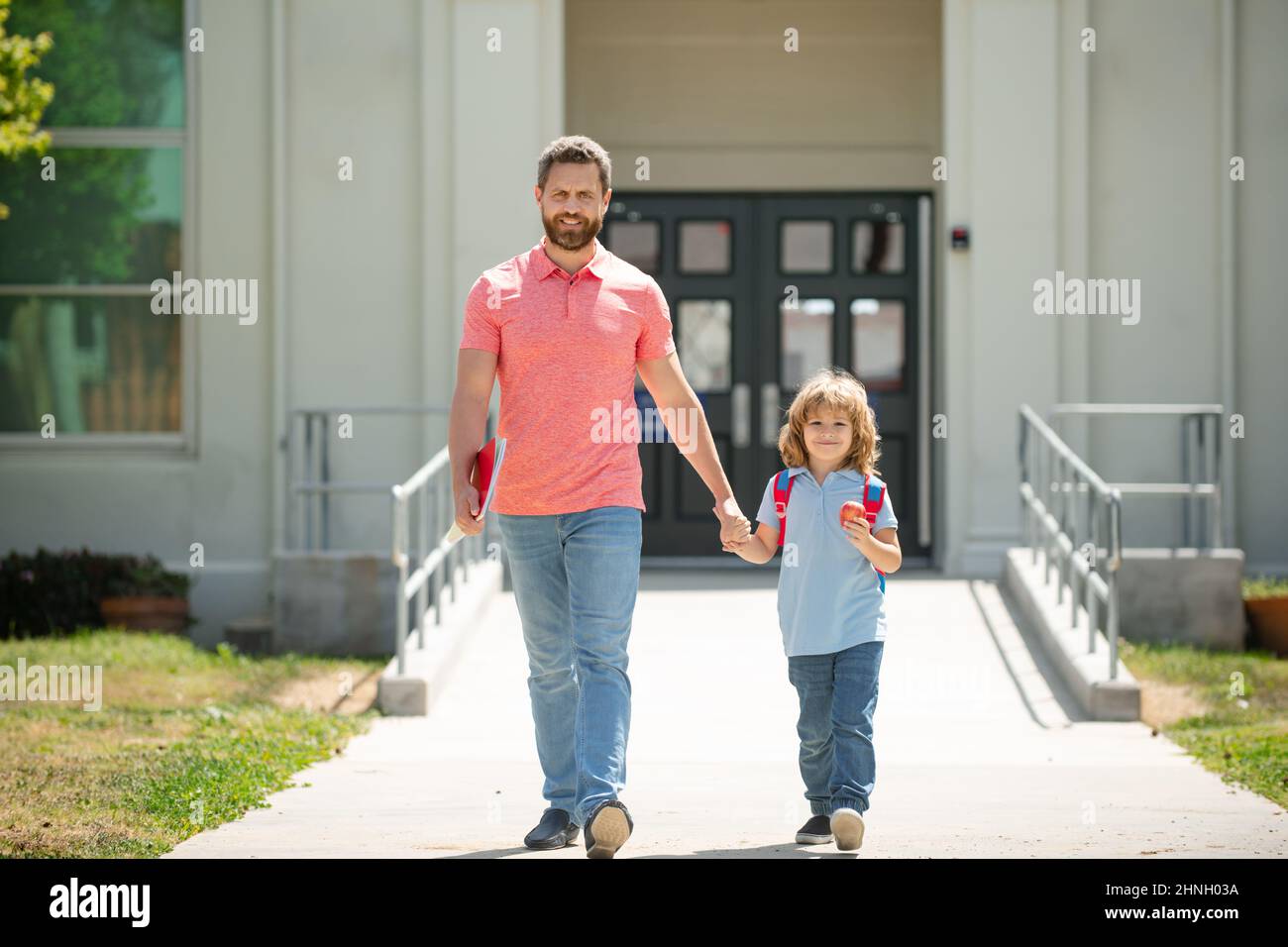 Father supports and motivates son. Kid going to primary school. Parent