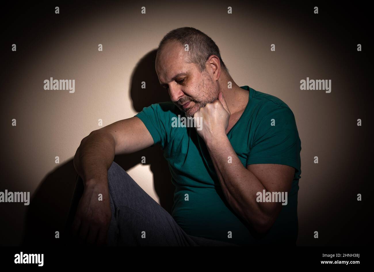 Mid age man suffering from anxiety, depression due to social seclusion, isolation, consequence of covid-19 Stock Photo