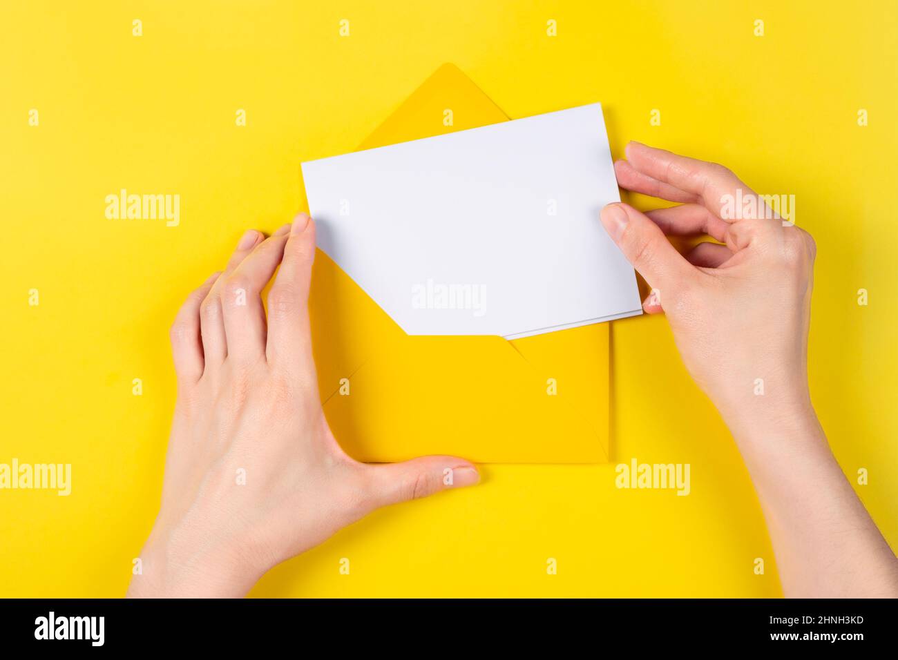 Top view on Hands put the card into the envelope. Blank white card with ...