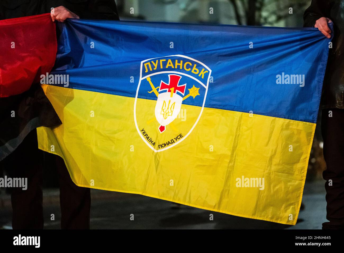 Flag of Ukraine with symbol, logo of Luhansk or Lugansk city and battle flag of the UPA near the border with Russia in the disputed Donbass region Stock Photo