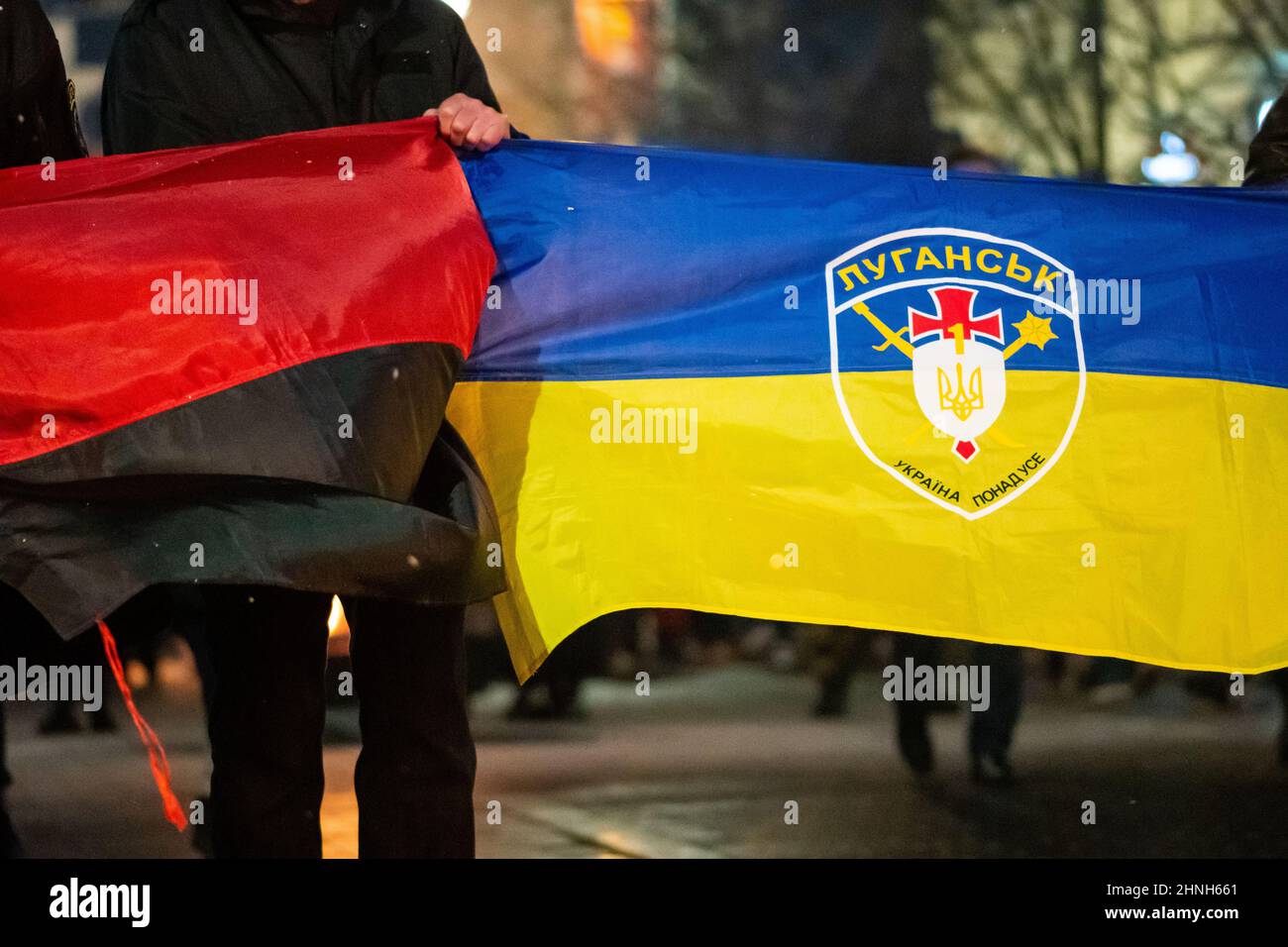 Flag of Ukraine with symbol, logo of Luhansk or Lugansk city and battle flag of the UPA near the border with Russia in the disputed Donbass region Stock Photo