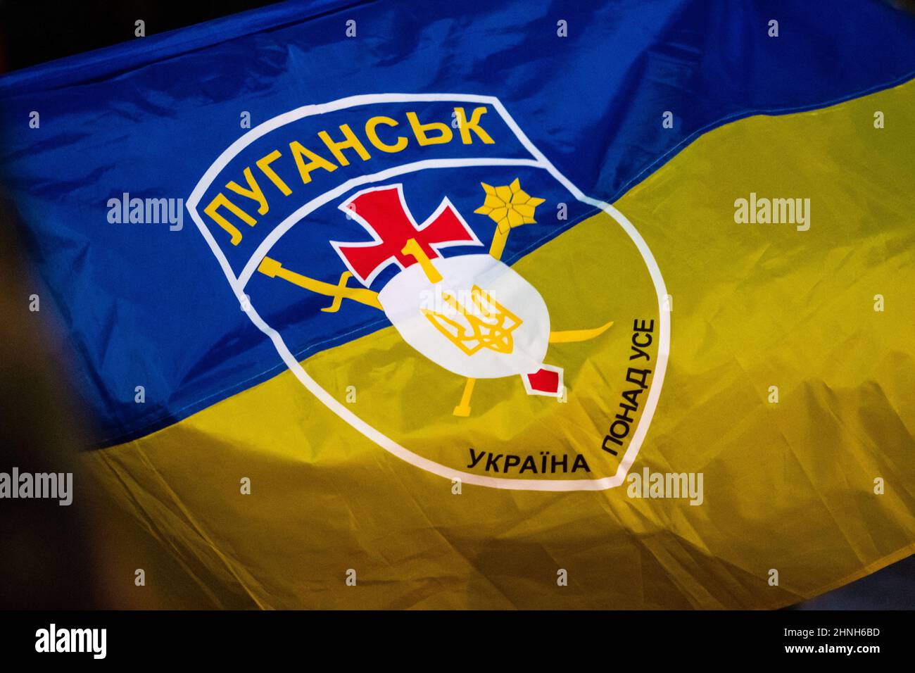 Flag of Ukraine above all with silhouette of symbol or logo of Luhansk or Lugansk city near the border with Russia in the disputed Donbass region Stock Photo