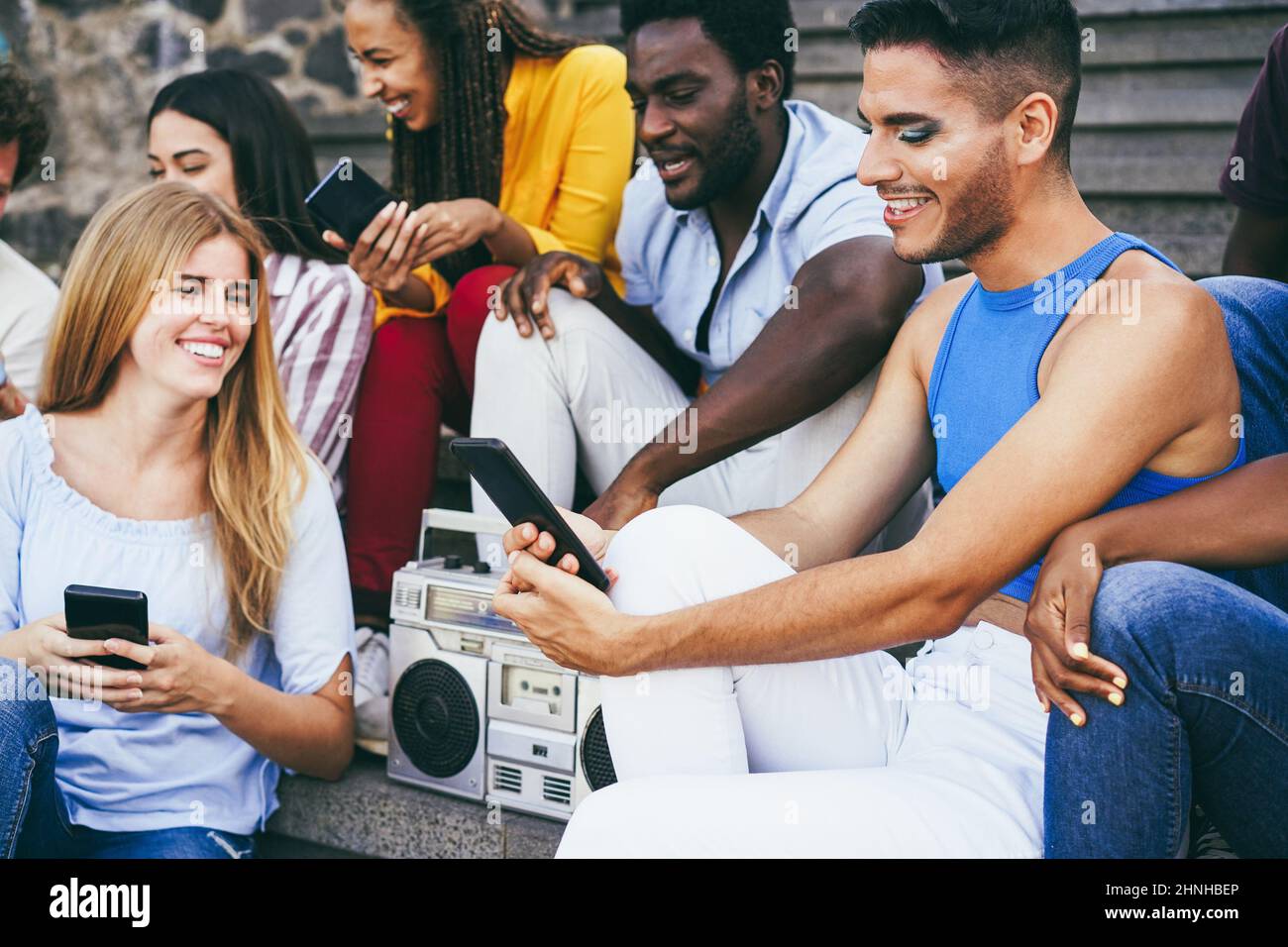 Young diverse people dancing and listening music with boombox stereo outdoor - Focus on transgender face Stock Photo