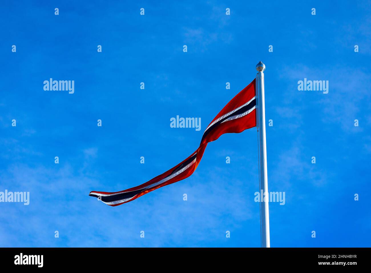 The Norway flag waving in the wind against a light blue sky on a sunny ...