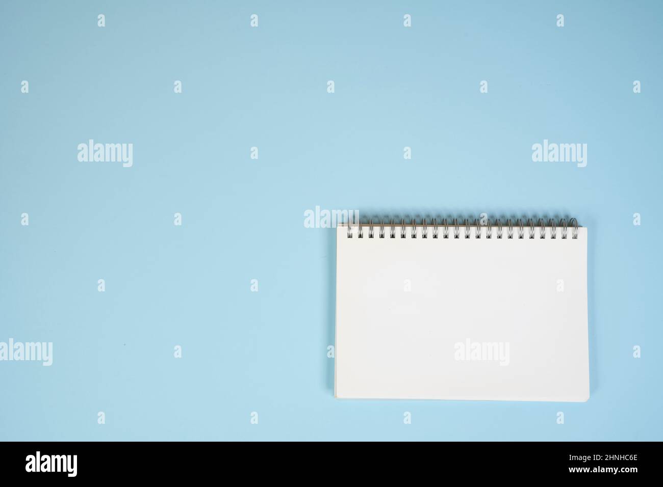 a blank white notepad on a blue surface Stock Photo