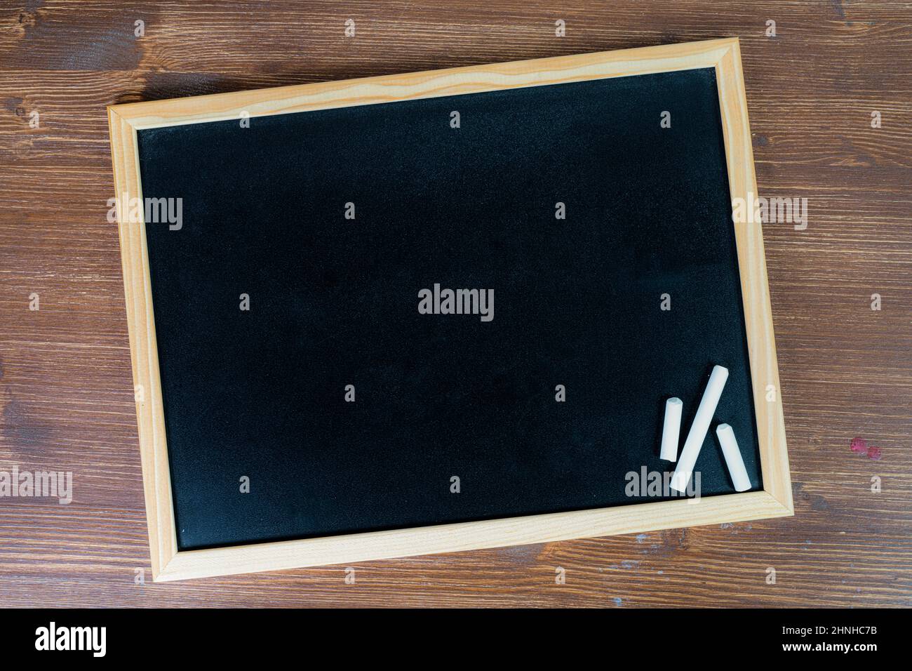 a blank black chalkboard on a wooden surface Stock Photo