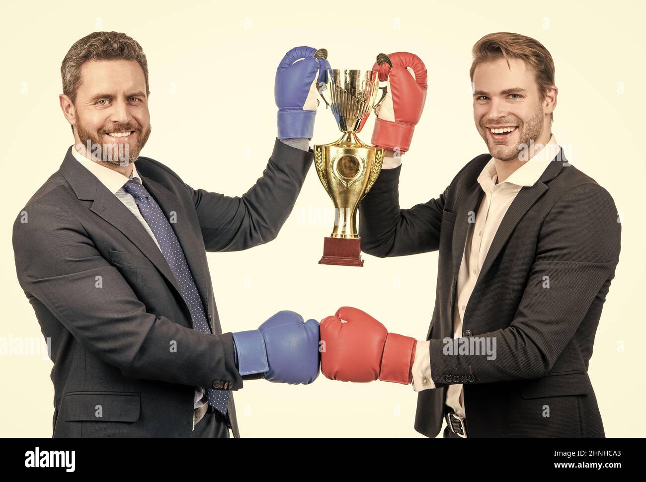 two happy businessmen in boxing gloves hold champion cup after battle