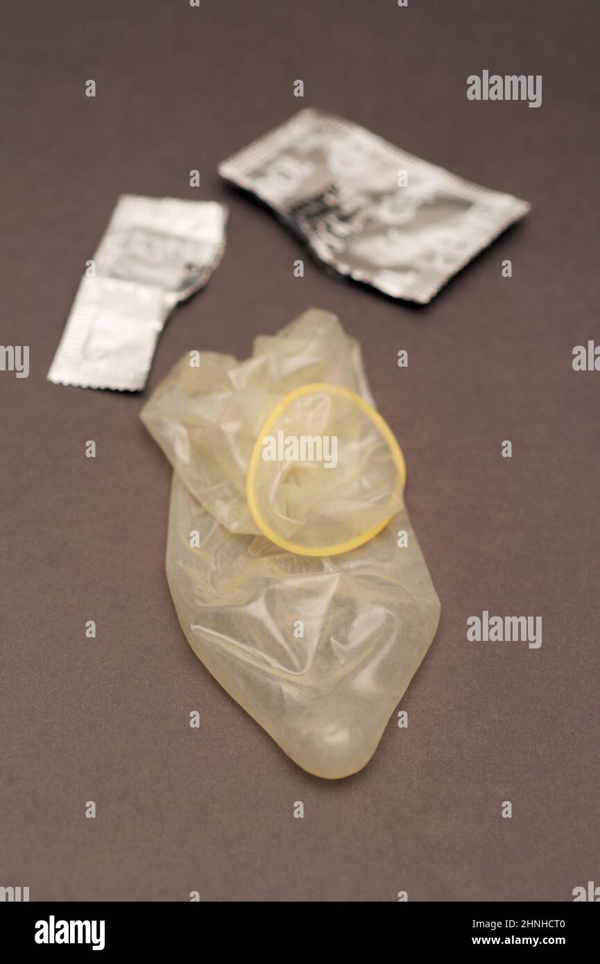 a used condom and teared condom wrapper Stock Photo