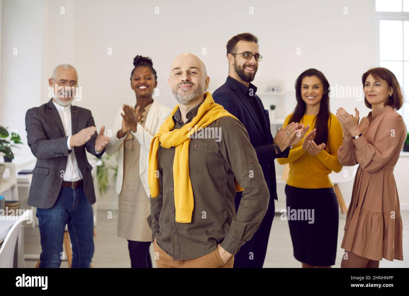 Smiling diverse employee greeting male employee with promotion Stock Photo