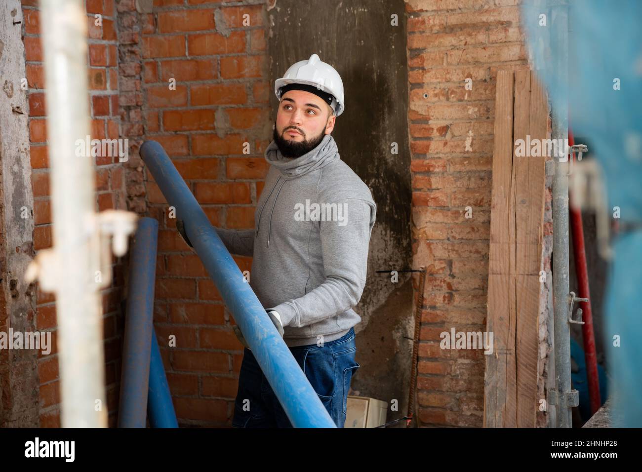 Guy working with plastic pipes at building site Stock Photo Alamy