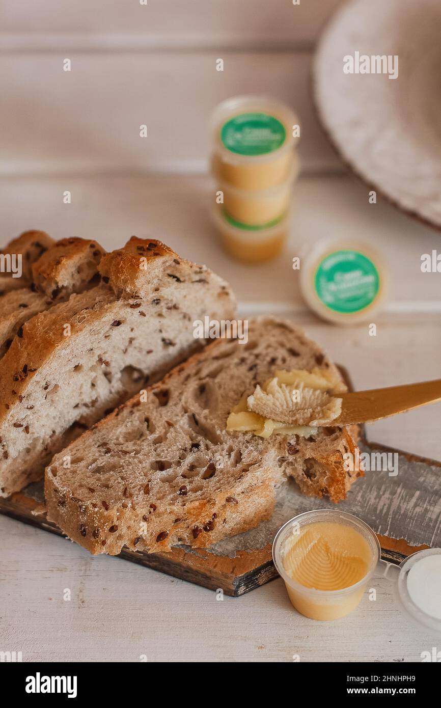 Ghee butter in glass jar and sliced bread on table. Healthy eating