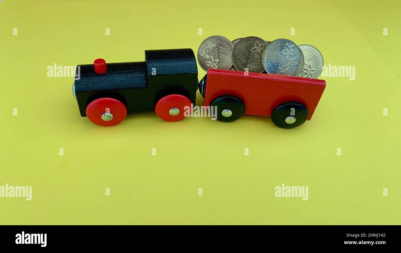 Toy train carry gold coins. Investment and business concept. Stock Photo