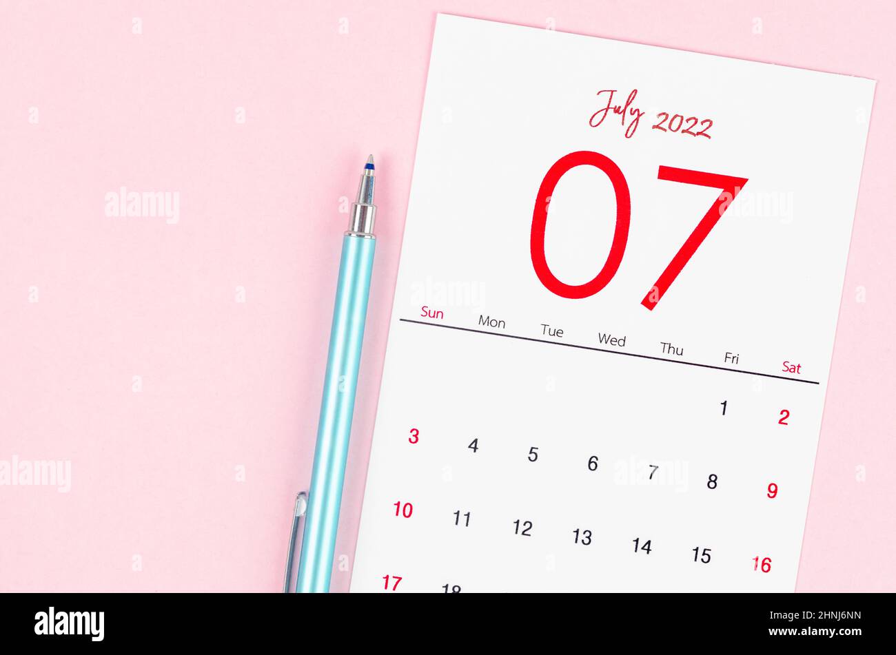 The July 2022 calendar with pen on pink background. Stock Photo