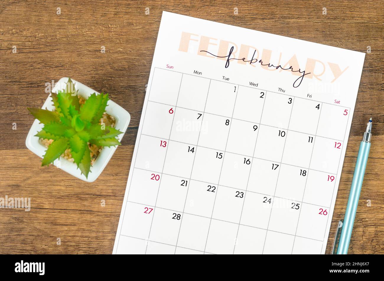 the february 2022 calendar and pen on wooden background stock photo alamy