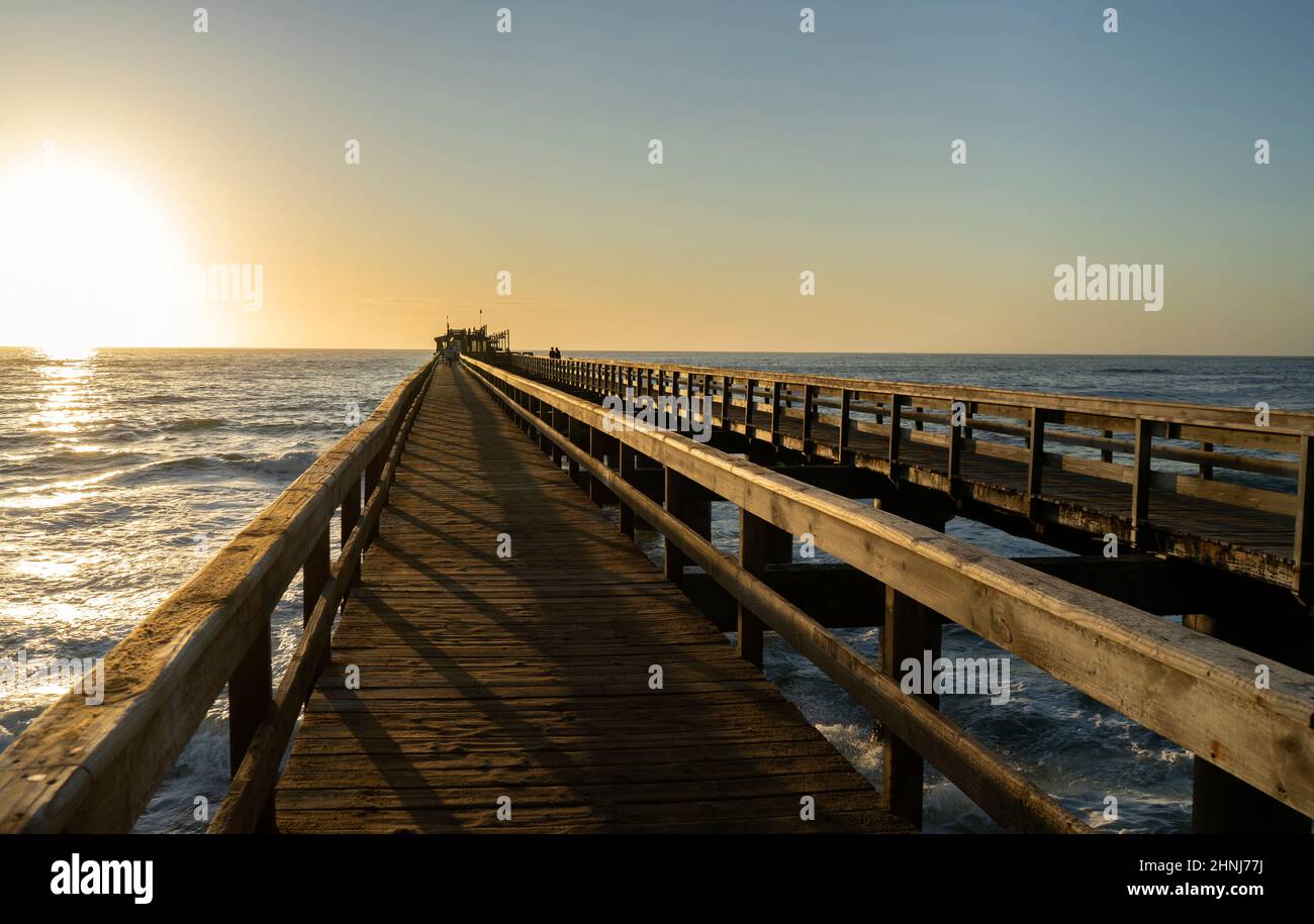 Old long wooden jetty at sunset Stock Photo