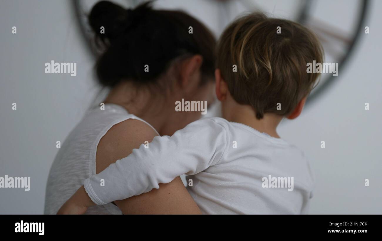 Mother multi-tasking at home holding child in arms Stock Photo - Alamy