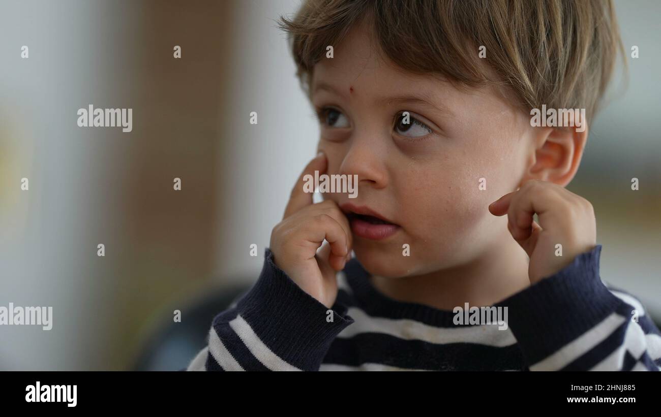 Toddler touching eyes and face with hand child rubbing face with finger