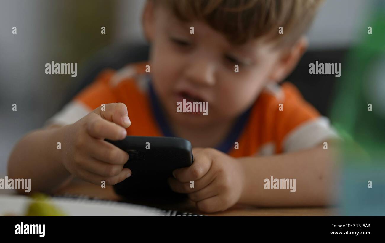 Upset little boy angry with technology child hitting phone screen being frustrated Stock Photo