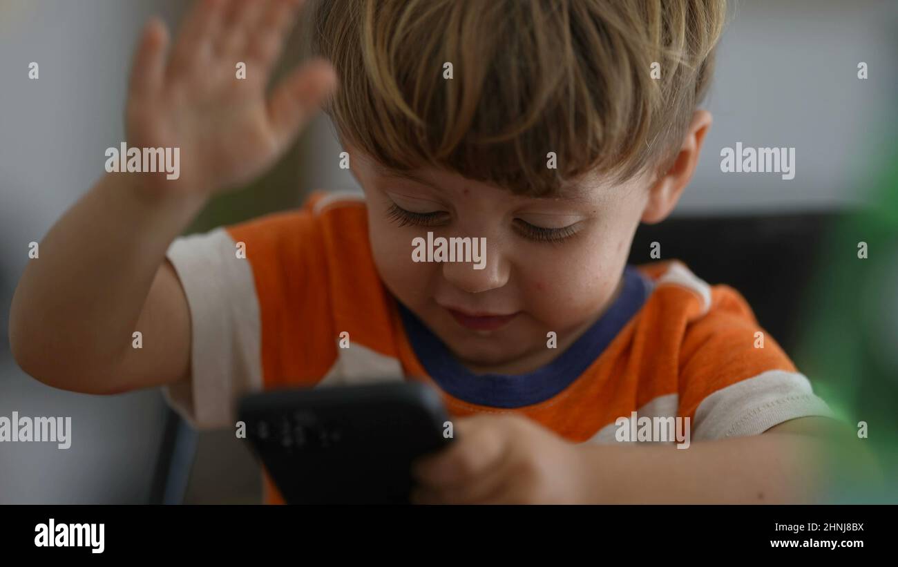 Upset little boy angry with technology child hitting phone screen being frustrated Stock Photo