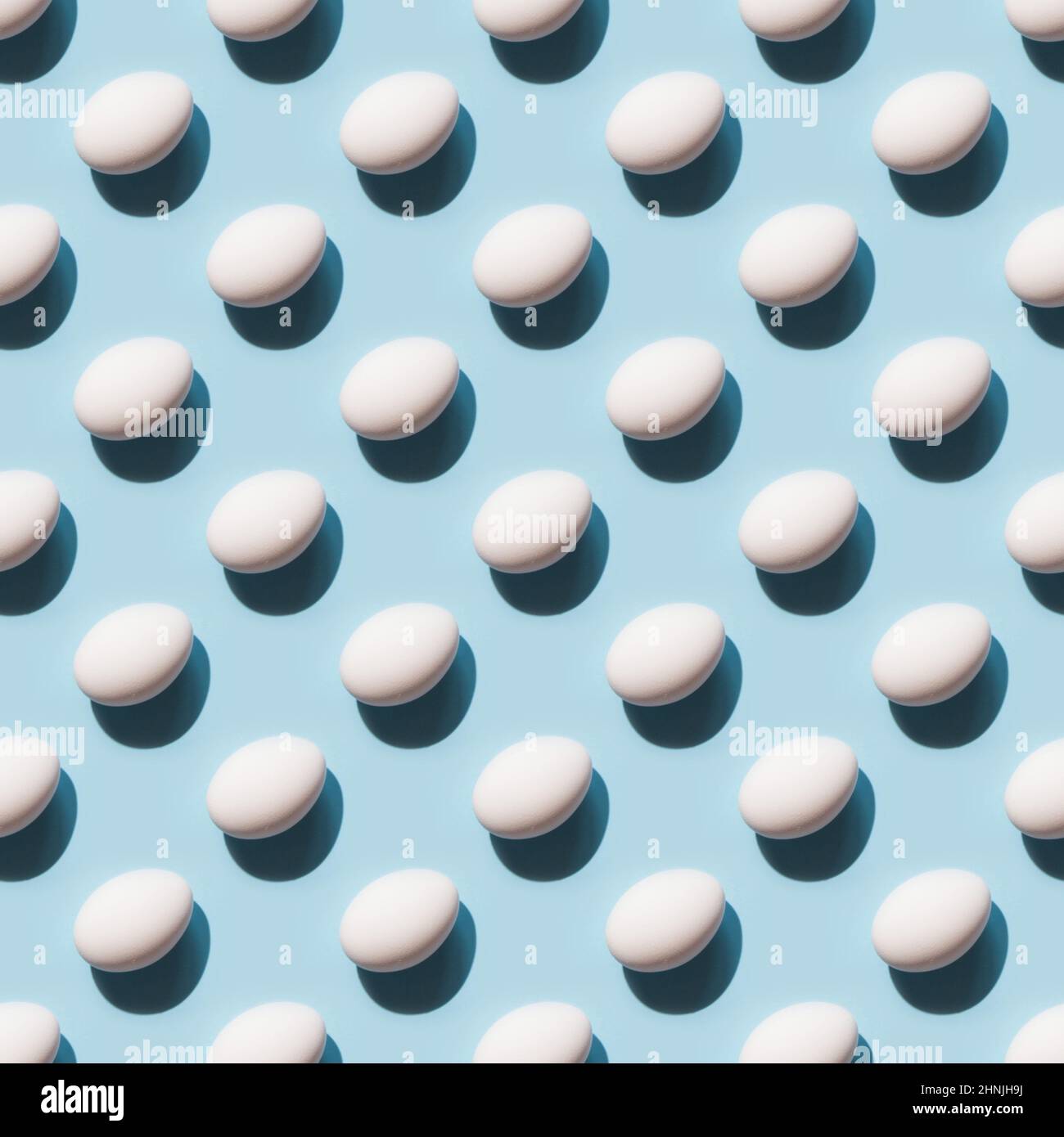 Organic white eggs on blue background. Abstract pattern. Eggs in isometric. Stock Photo