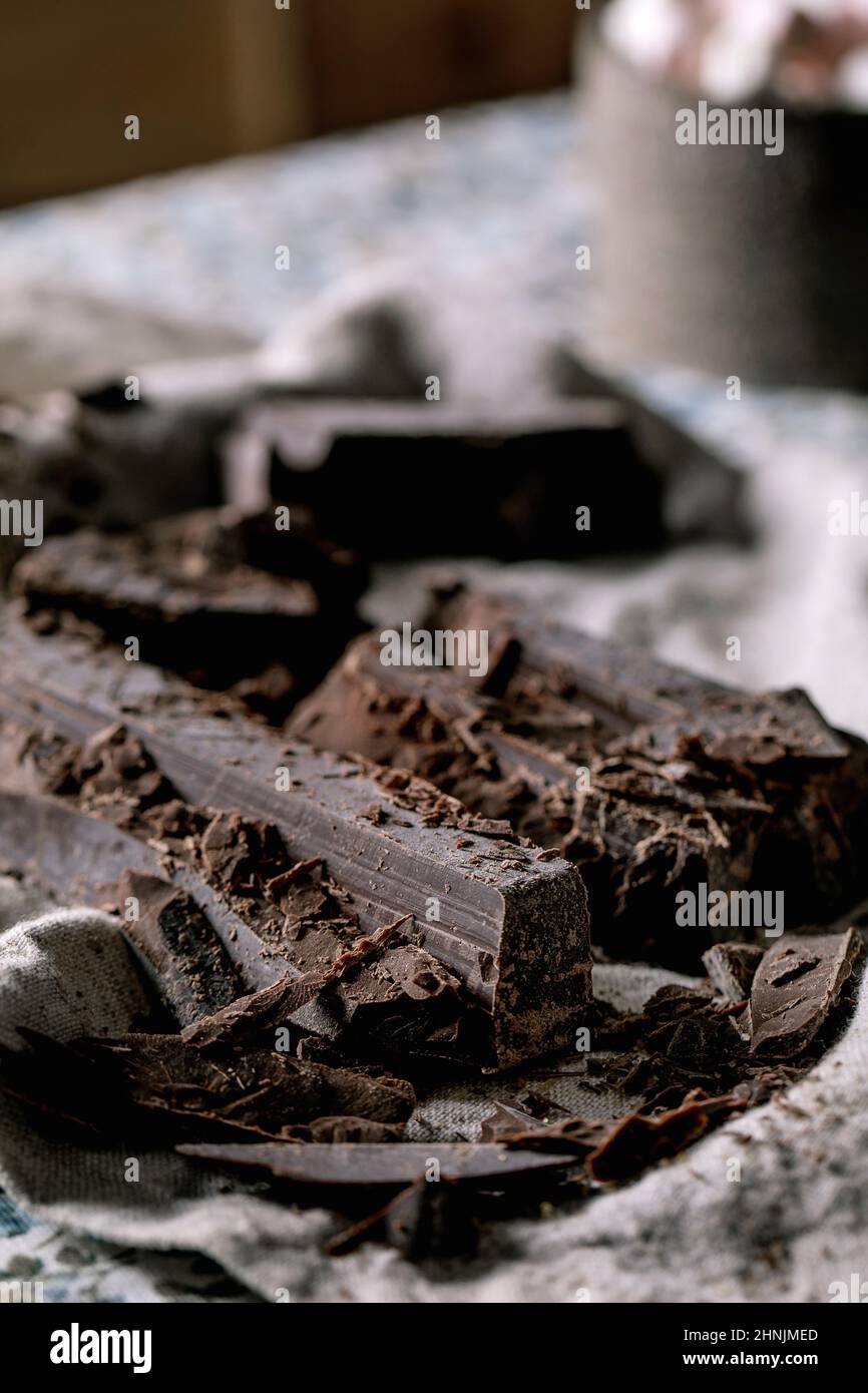 Ingredients for make hot chocolate winter drink. Chopped dark chocolate, species, cane sugar, marshmallows on rustic linen tablecloth in country kitch Stock Photo
