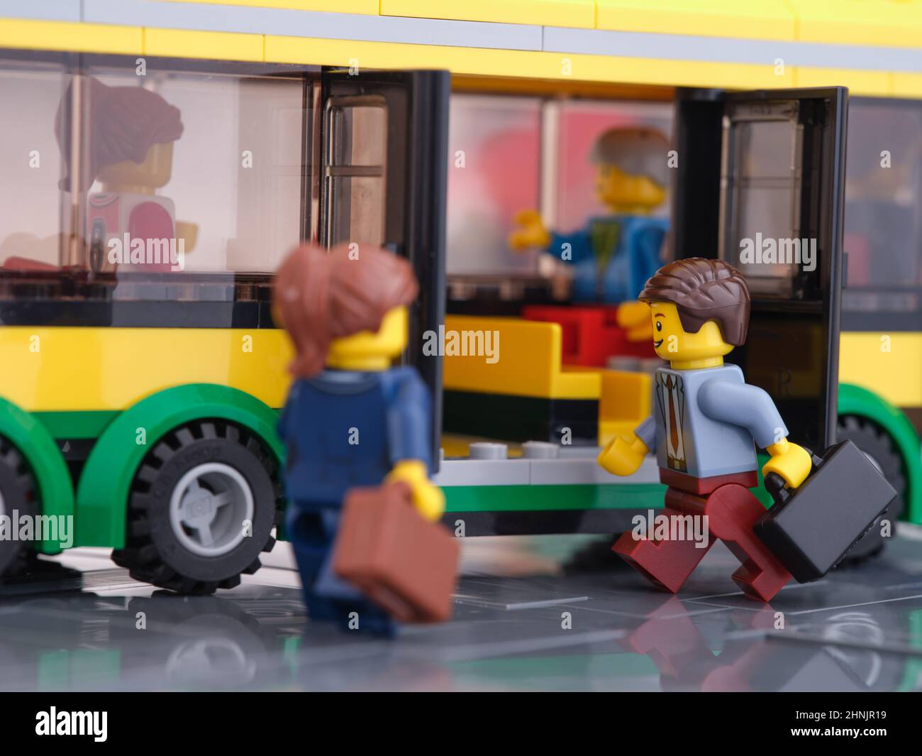Tambov, Russian Federation - February 16, 2022 Two Lego businessperson minifigures who are holding suitcases getting on to a bus. Stock Photo