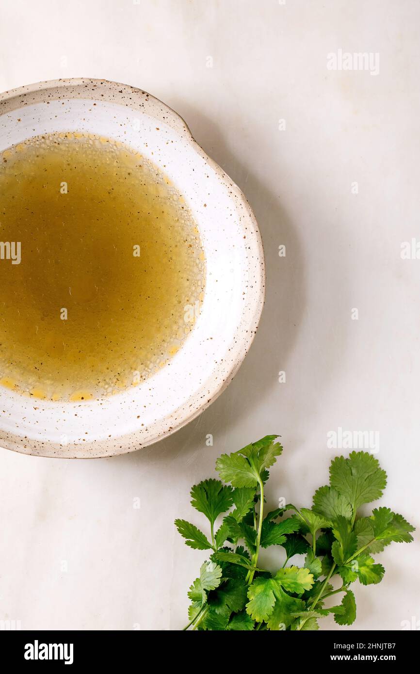 Clear homemade chicken or duck broth bouillon in ceramic bowl with