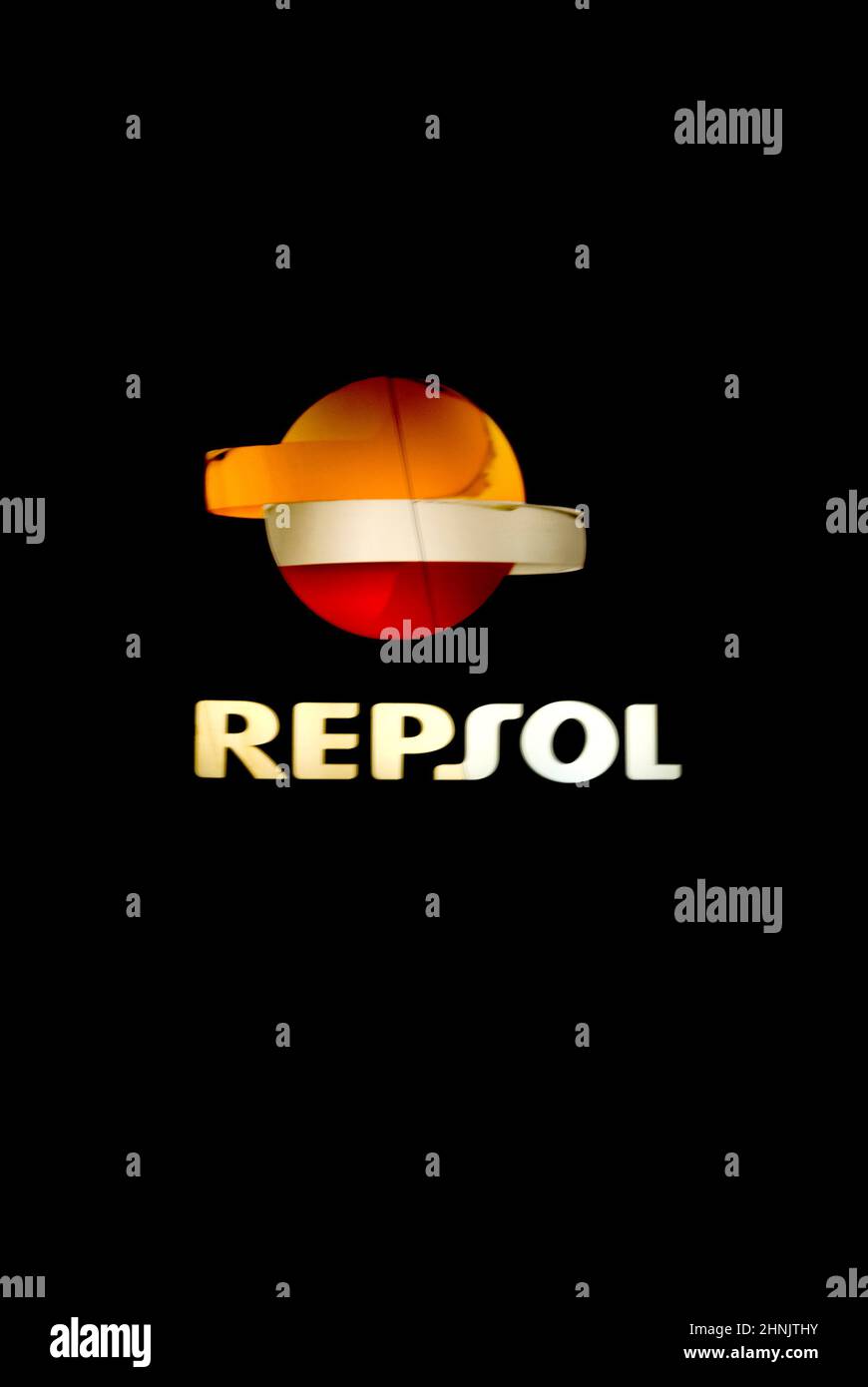 luminous sign of Repsol gas station with isolated black background in vertical Stock Photo