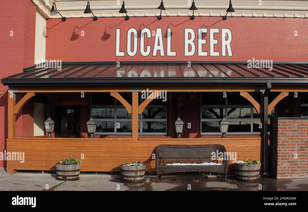 Local Beer Sign on Local Rural Cafe Restaurant With Snow on Bench Stock Photo