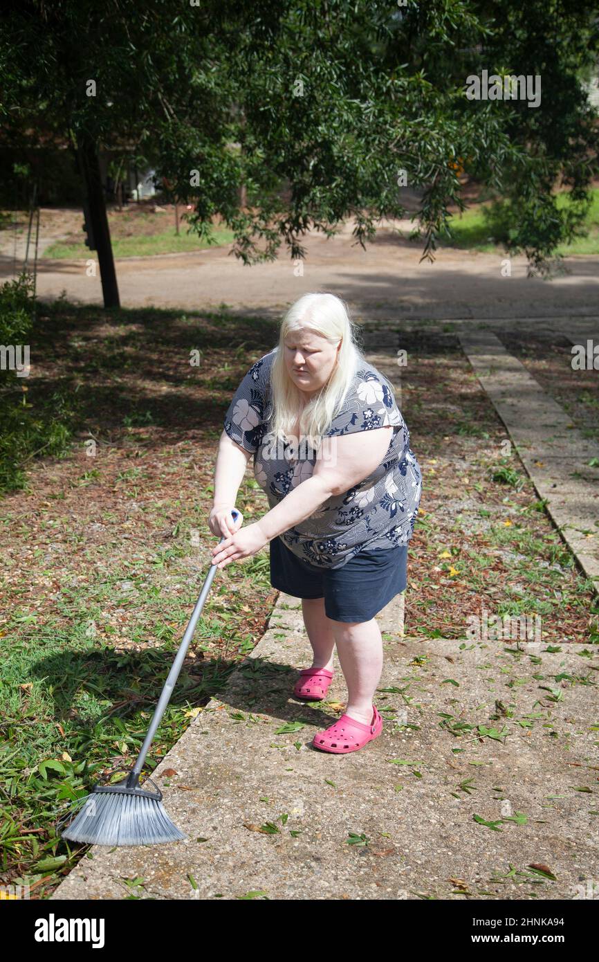 Woman Cleaning a Yard Stock Photo