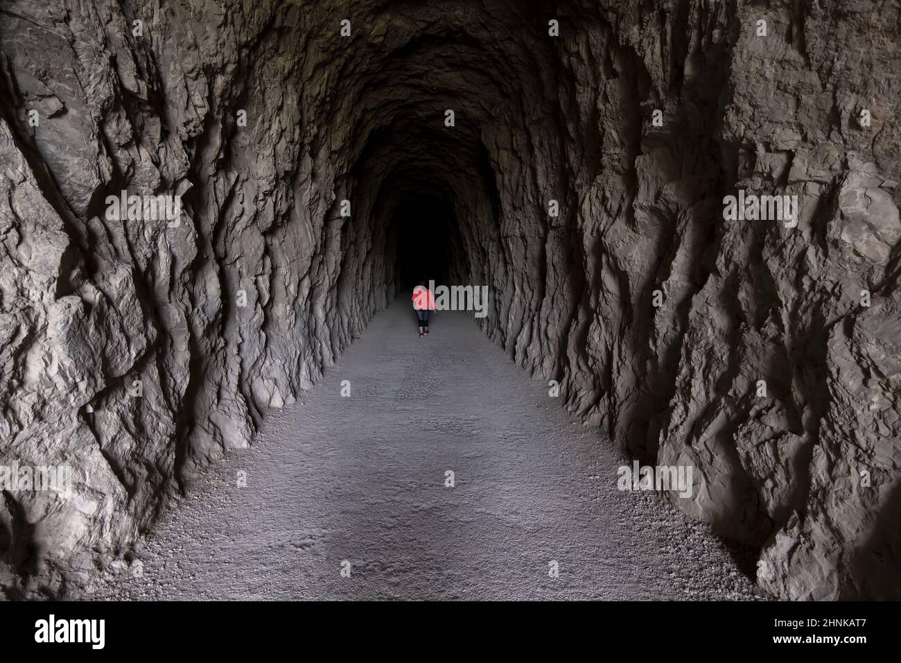 Woman in dark tunnel Stock Photo