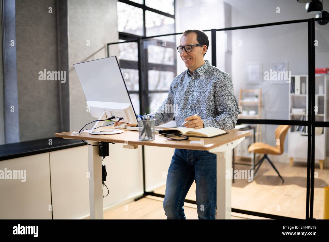 Man Using Adjustable Height Standing Desk In Office For Good Posture
