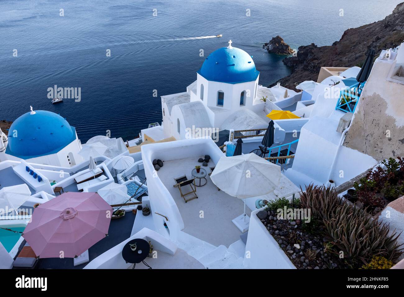 View from viewpoint of Oia village with blue domes of  greek orthodox Christian churches and traditional whitewashed greek architecture.  Santorini, Greece Stock Photo