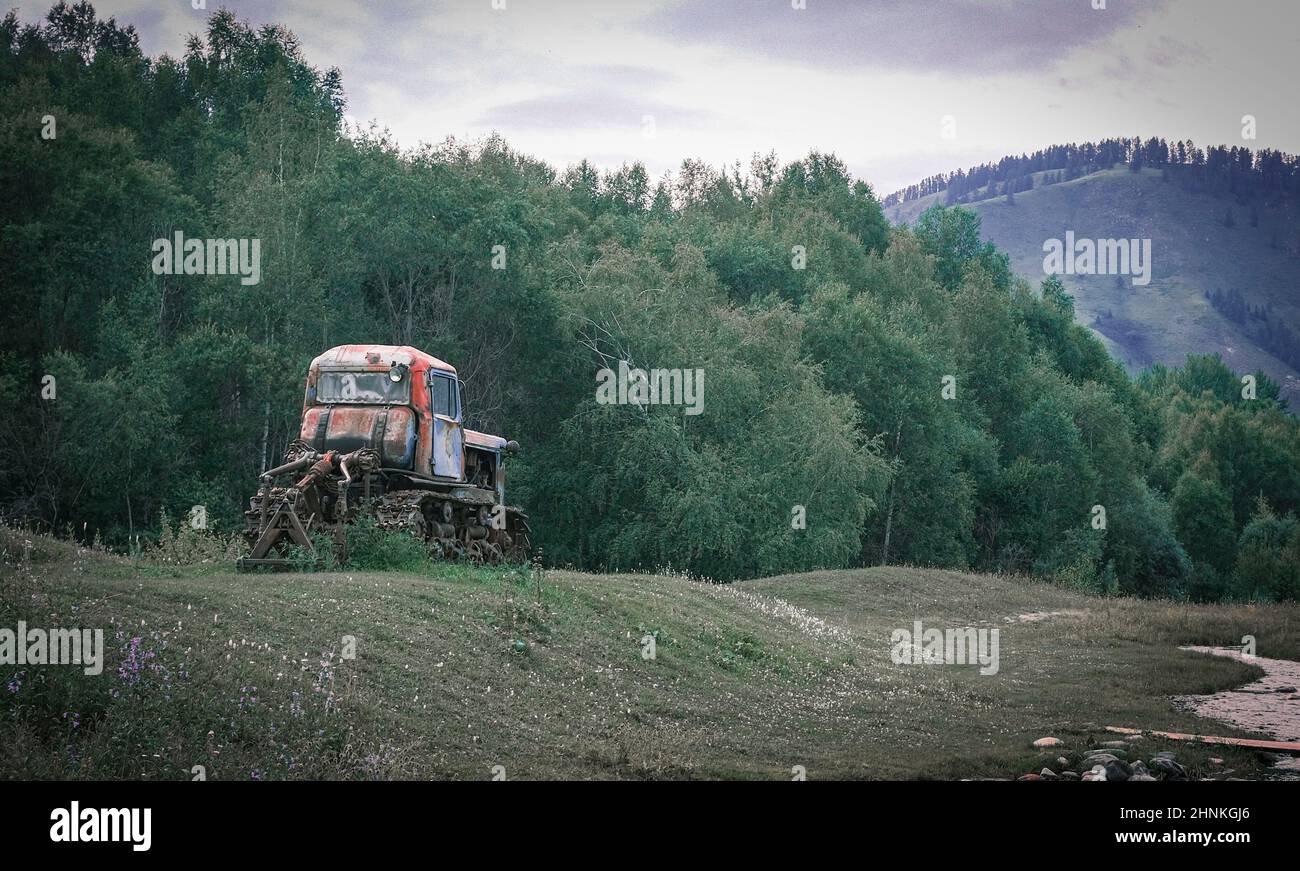 An old crawler tractor in rural landscape Stock Photo
