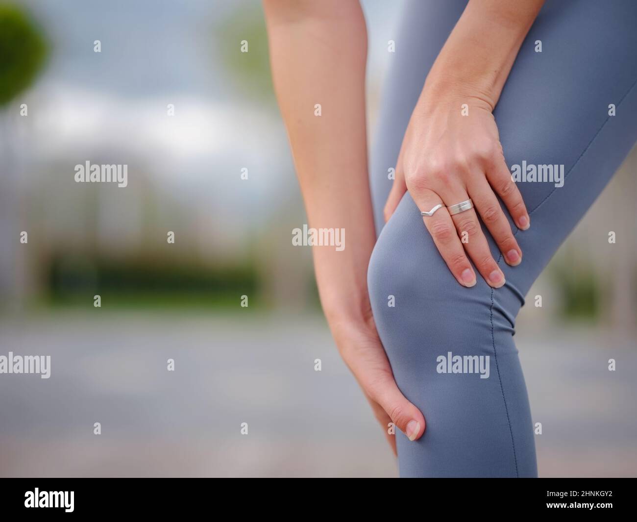 pain and from knee injury during morning run. Young woman