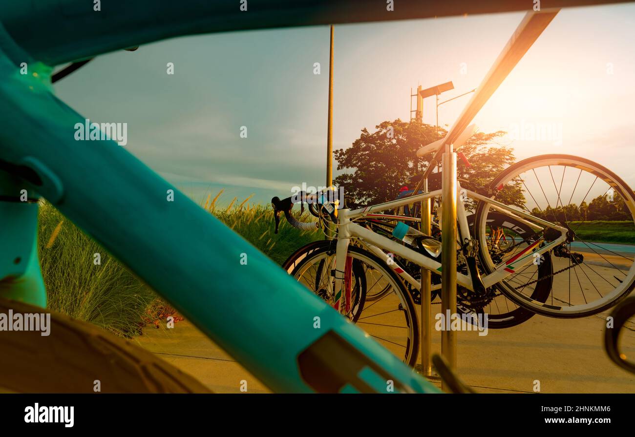 Bicycle parked on aluminium rack at the park. Outdoor exercise and recreation activity. Bicycle at bike parking station. Eco-friendly. Healthy lifestyle. Outdoor activity in summer. Extreme sport. Stock Photo