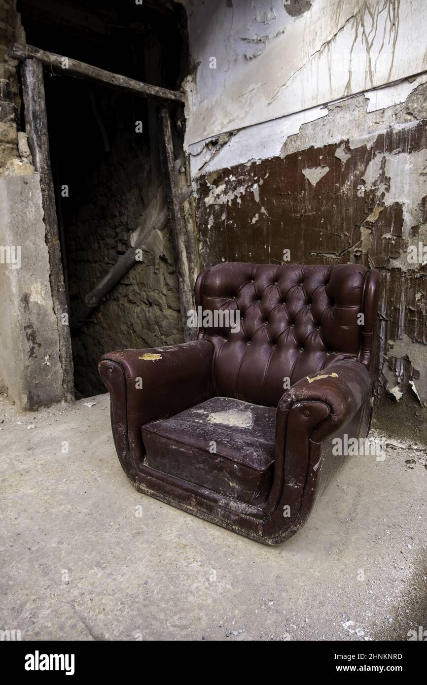 Old abandoned leather armchair Stock Photo