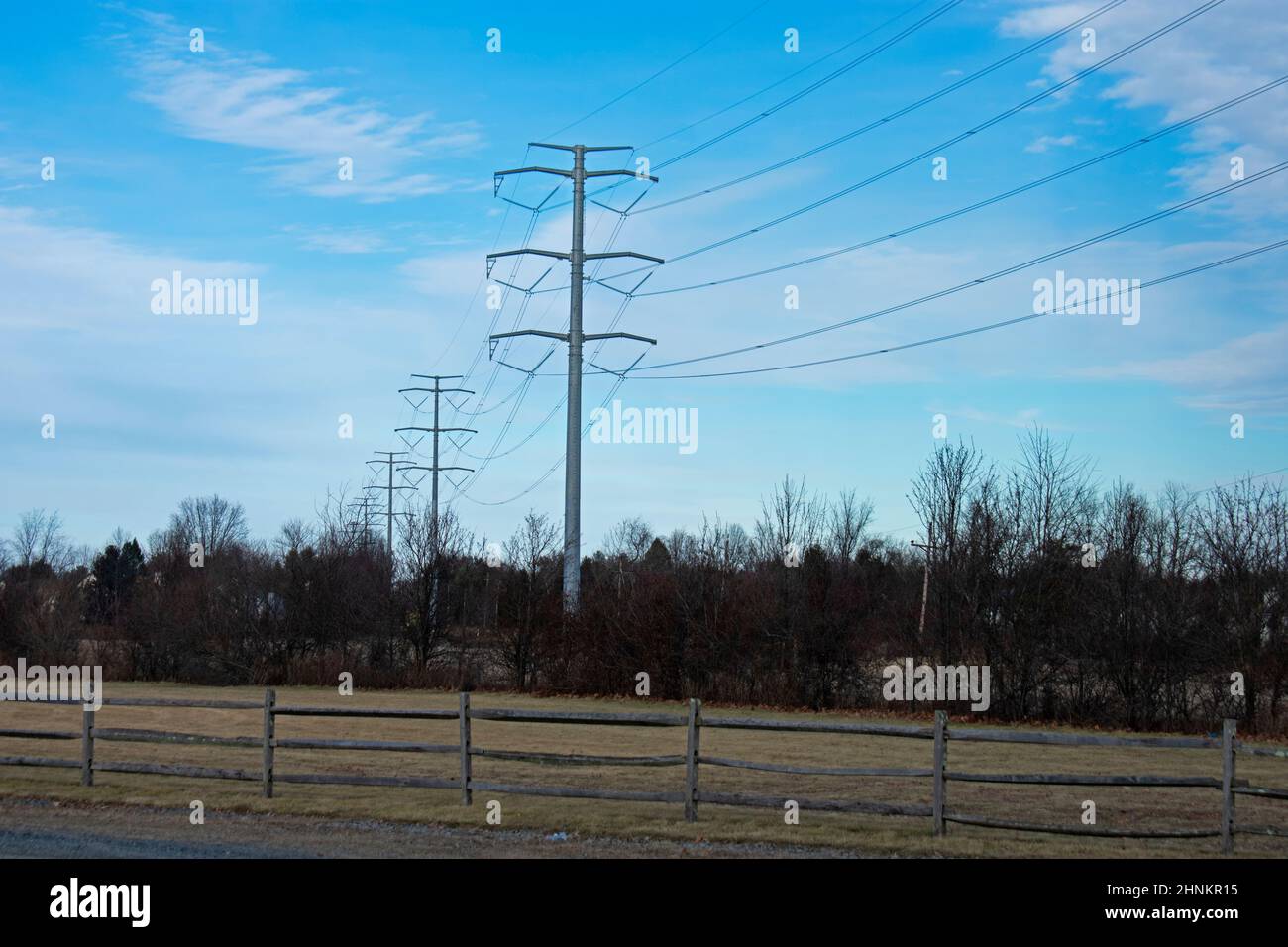 High voltage electrical power towers and cables against a blue sky on a ...