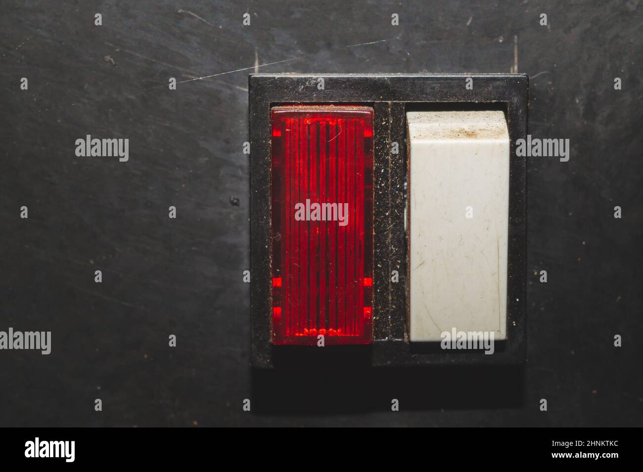 Vintage switch with a red indicator on a black background. white toggle