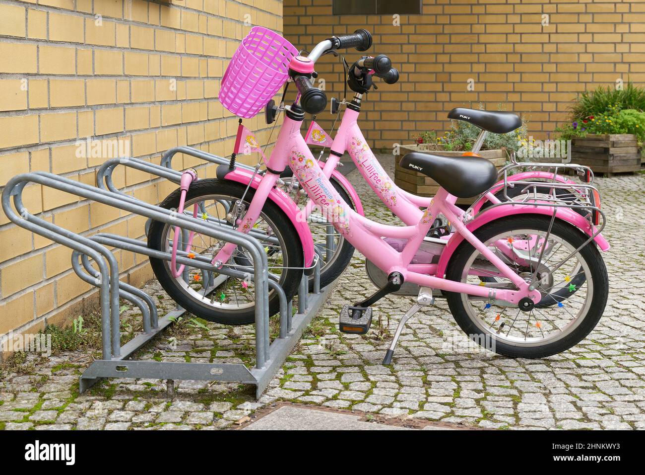 pink bicycles as merchandising of the product line Lillifee from the german publishing house Coppenrath in front of a kindergarten in Berlin Stock Photo