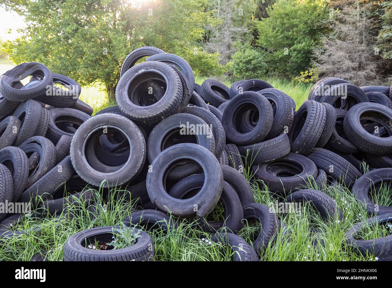 Damaged and worn old black tires on a stack. Damaged and worn old black tires on a stack. Tire tread problems. Solutions concept. Tire tread problems. Stock Photo