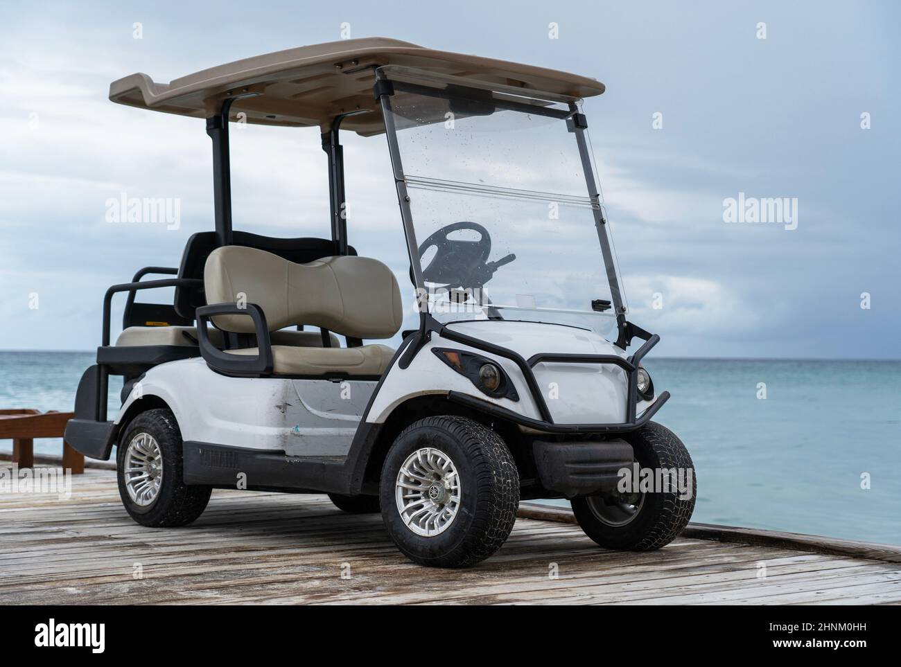 Golf car near the pier by the sea Stock Photo