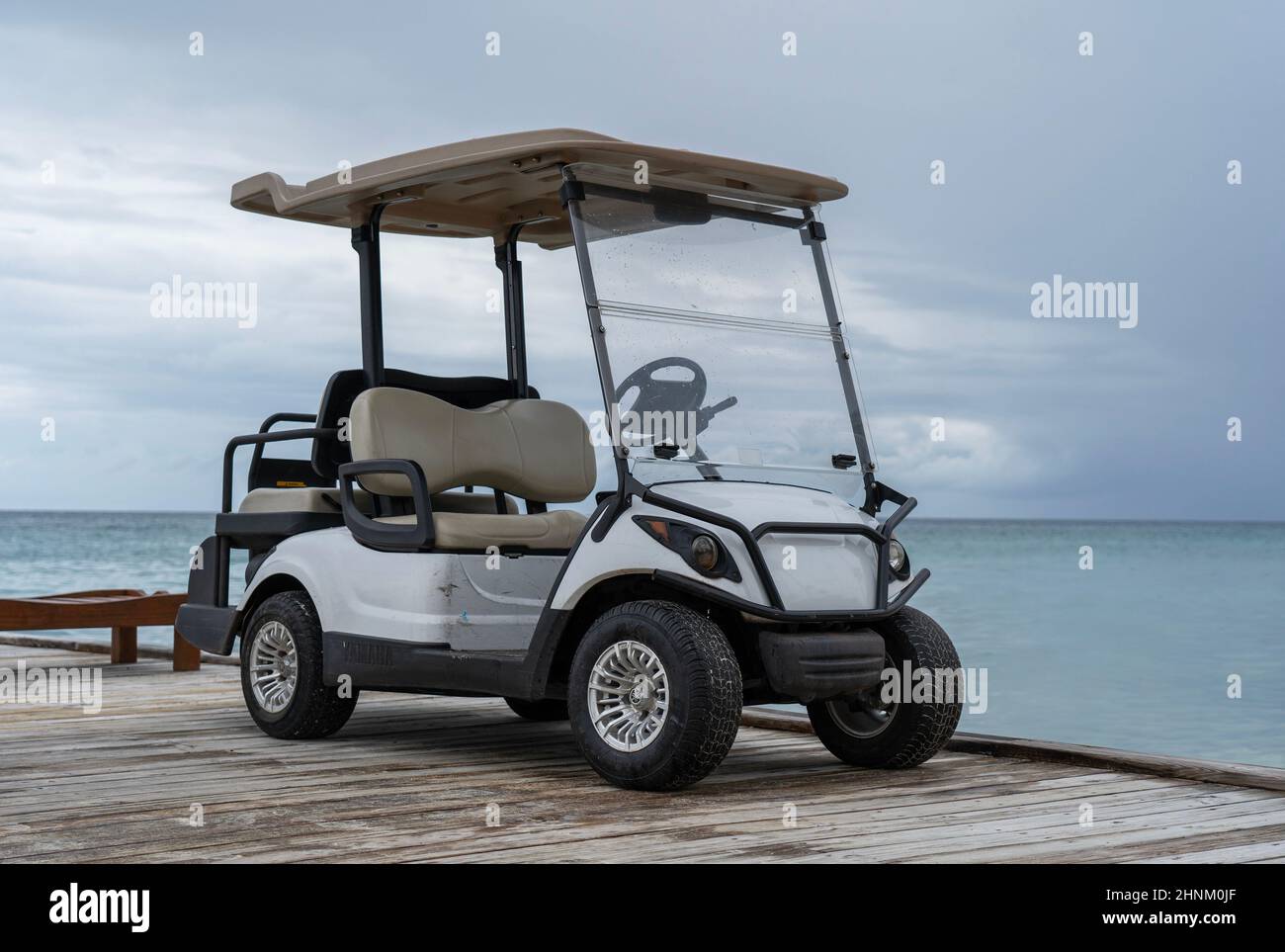 Golf car near the pier by the sea Stock Photo